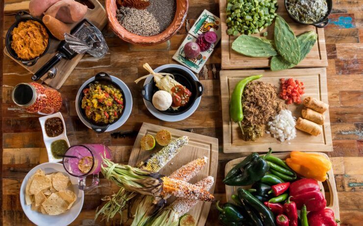 Mesa con antojitos de inspiración mexicana: elote, nopales, tamal y salsas, reflejo de la huella mexicana en la cocina de Arizona