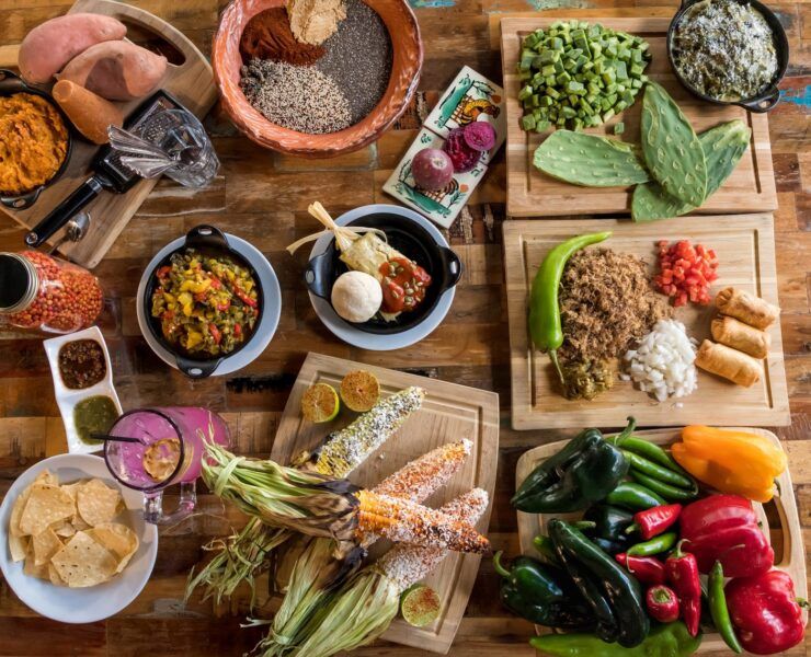 Mesa con antojitos de inspiración mexicana: elote, nopales, tamal y salsas, reflejo de la huella mexicana en la cocina de Arizona
