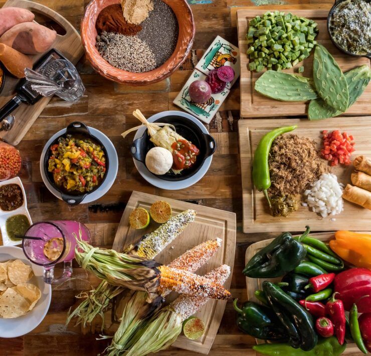 Mesa con antojitos de inspiración mexicana: elote, nopales, tamal y salsas, reflejo de la huella mexicana en la cocina de Arizona