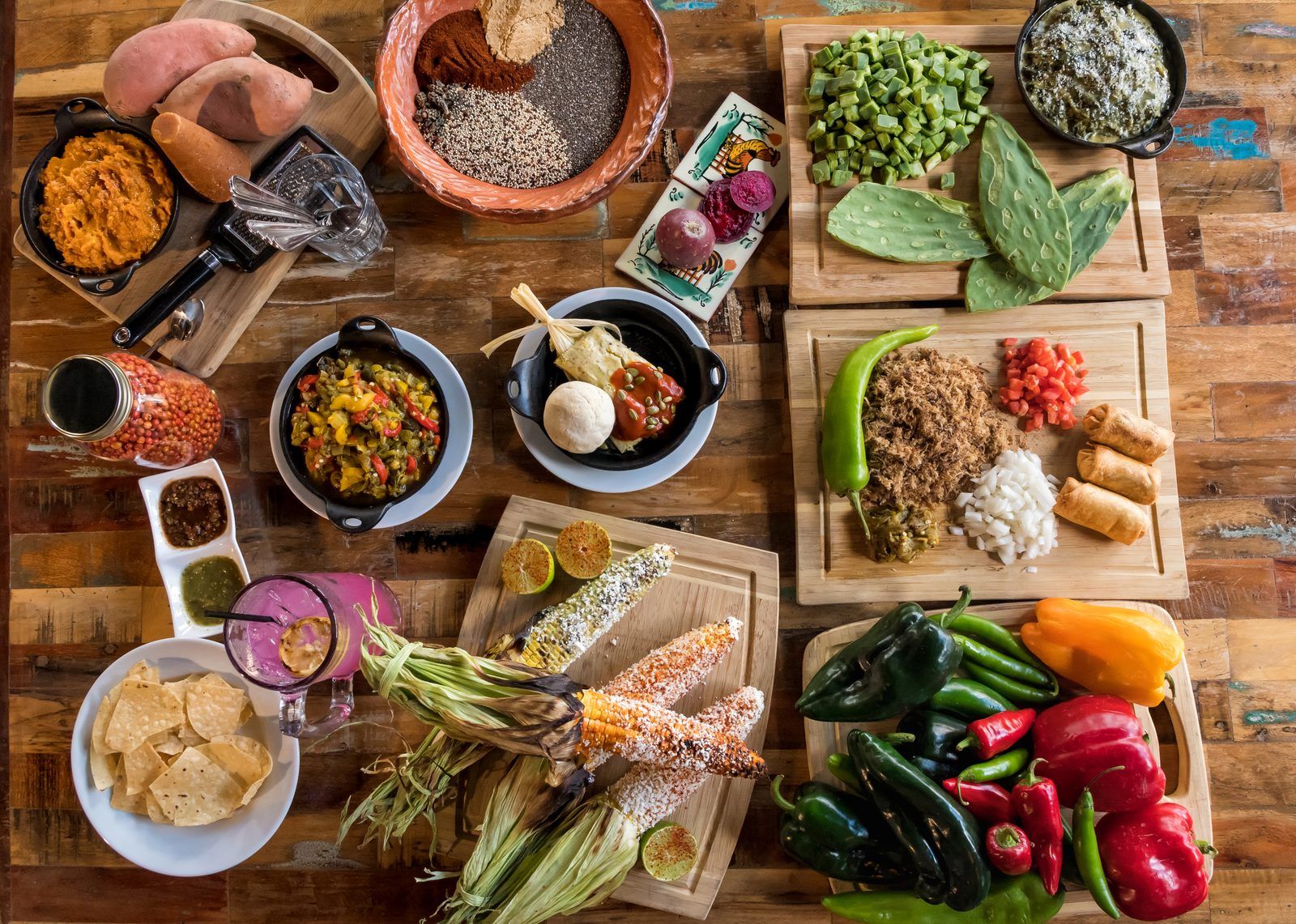 Mesa con antojitos de inspiración mexicana: elote, nopales, tamal y salsas, reflejo de la huella mexicana en la cocina de Arizona