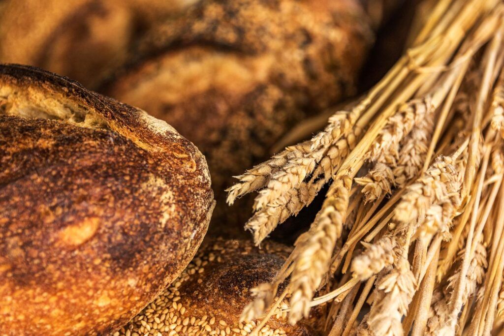 Panes artesanales recién horneados junto a espigas de trigo, tradición panadera de Arizona