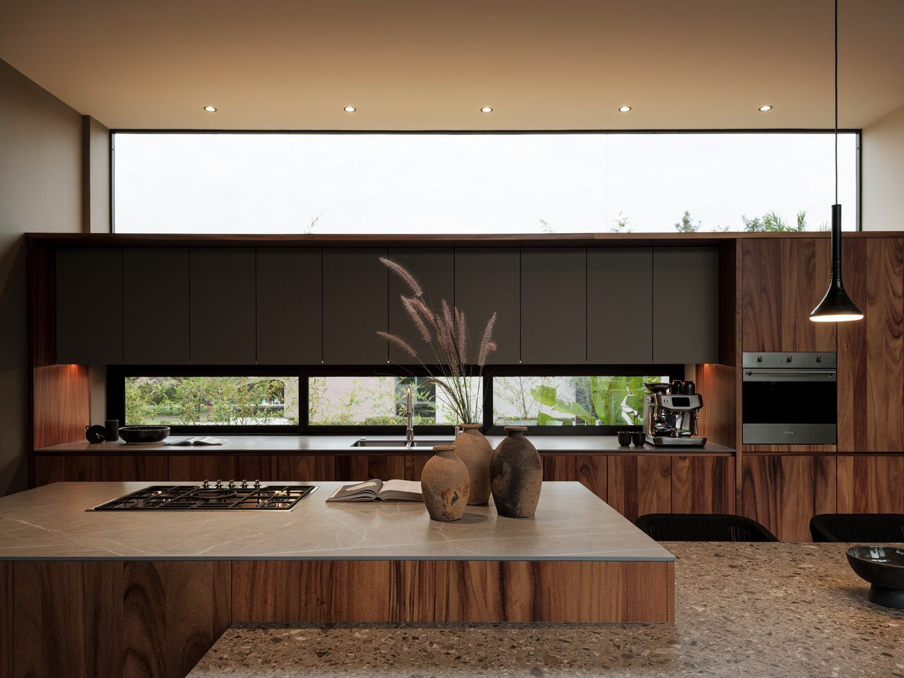 Cocina de Casa Kerany con madera, campana e isla de piedra