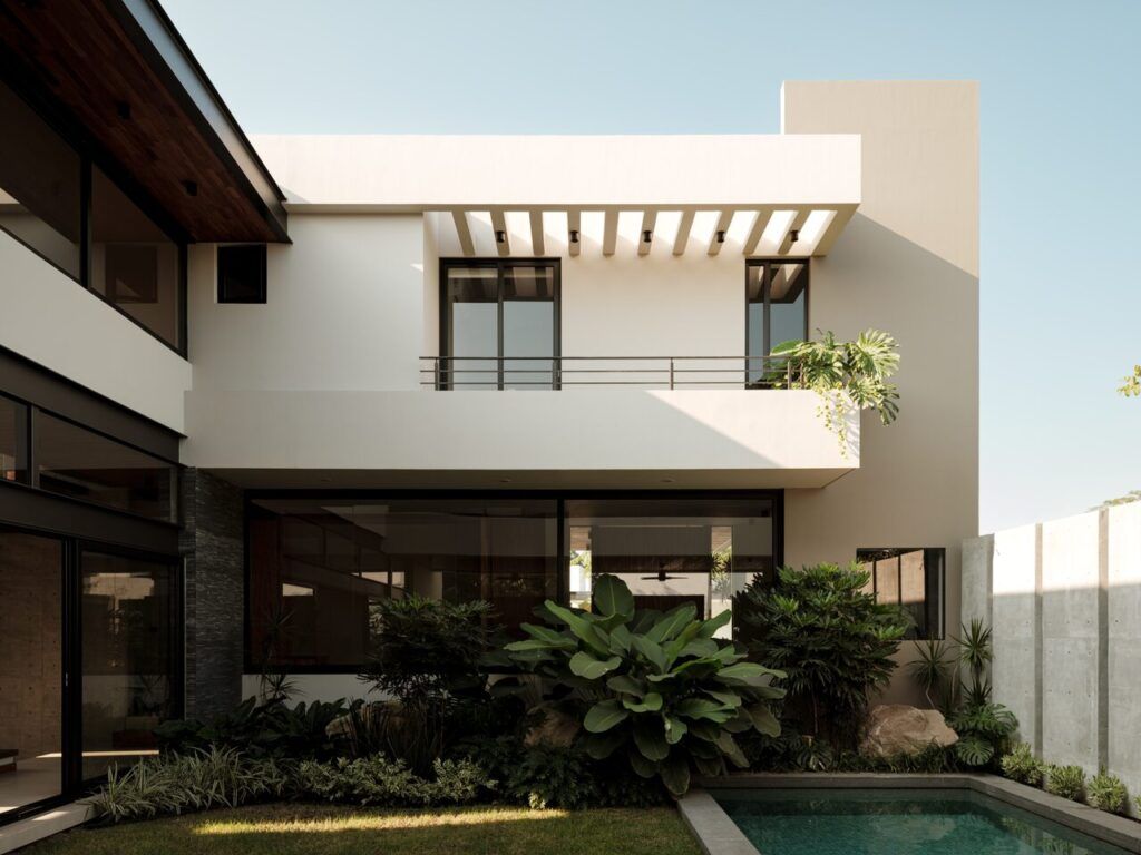 Casa Kerany vista desde el jardín con alberca, pérgola y vegetación