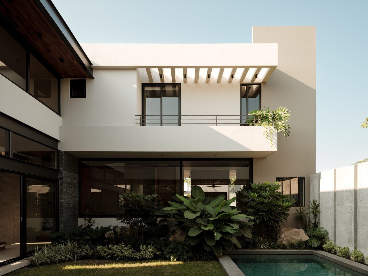 Casa Kerany vista desde el jardín con alberca, pérgola y vegetación