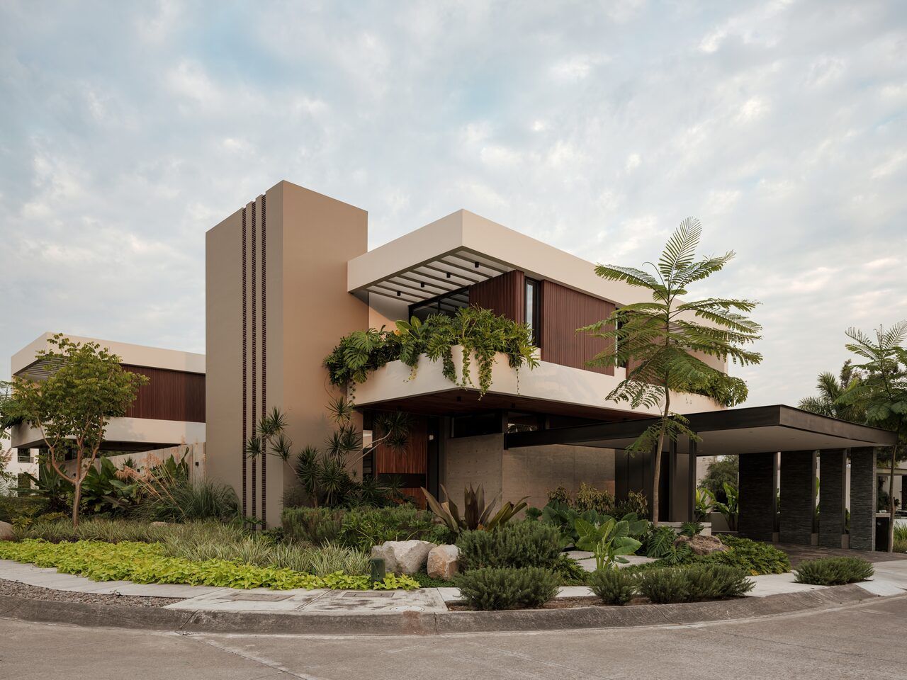 Casa Kerany al atardecer, vista de esquina con jardín y vegentació