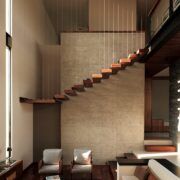 Sala a doble altura de Casa Kerany con escalera flotante