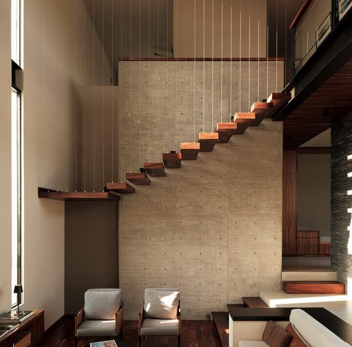 Sala a doble altura de Casa Kerany con escalera flotante