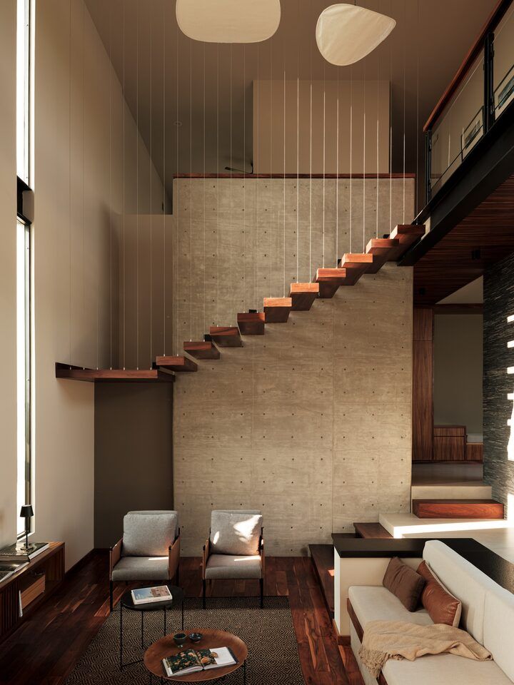 Sala a doble altura de Casa Kerany con escalera flotante