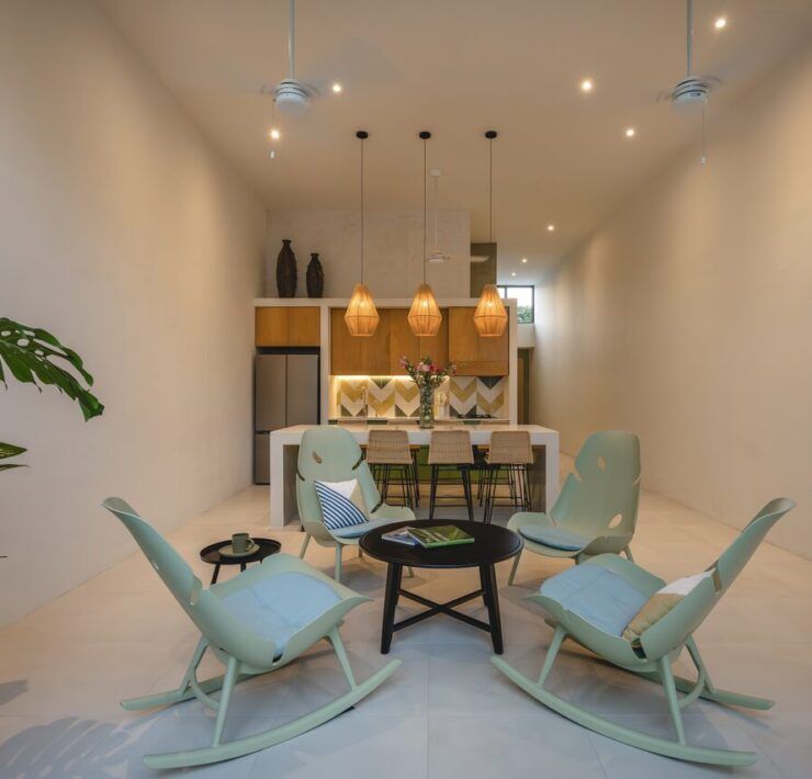 Comedor de Casa Mikelín con sillas y vegetación interior bajo doble altura