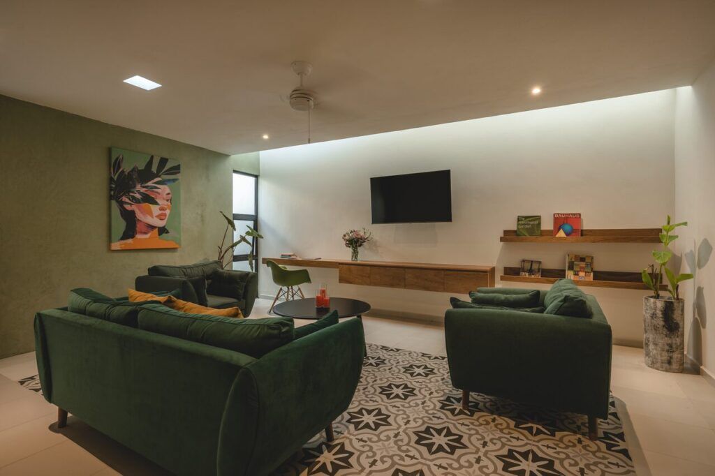 Sala de Casa Mikelín con sofá verde y piso de pasta artesanal