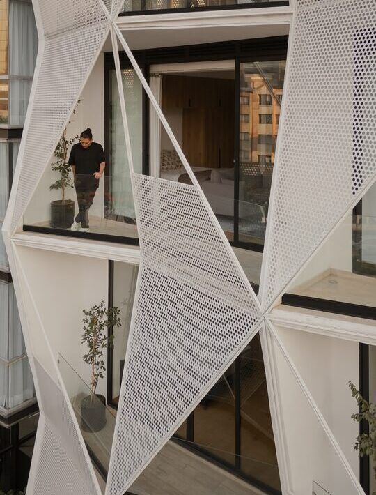 Terraza semiabierta con balcón triangular y vegetación en Casa Roma 350