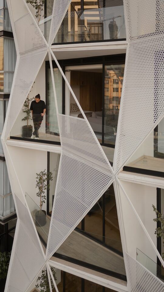 Terraza semiabierta con balcón triangular y vegetación en Casa Roma 350
