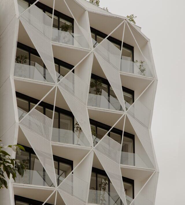 Casa Roma 350, edificio de departamentos en la Roma Norte con fachada triangular blanca, por Brag Arquitectos
