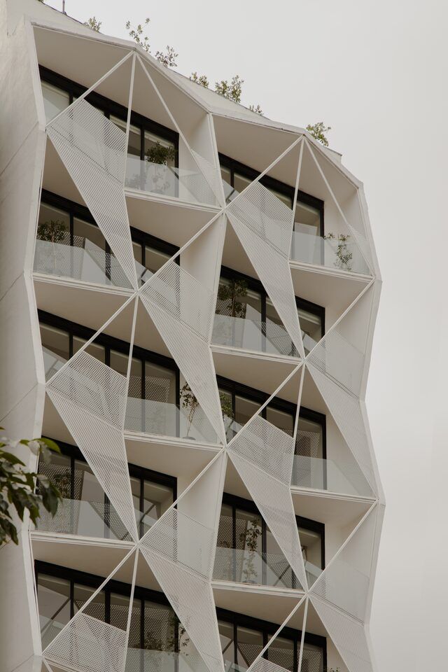 Casa Roma 350, edificio de departamentos en la Roma Norte con fachada triangular blanca, por Brag Arquitectos