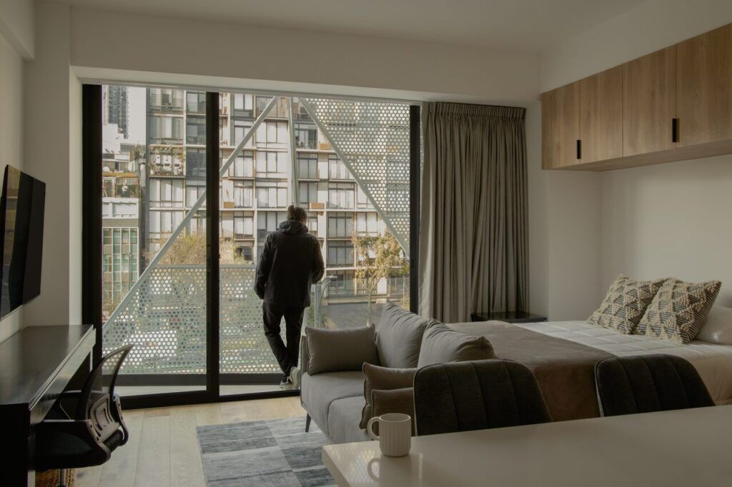 Interior de loft en Casa Roma 350 con ventanal y vista a la Ciudad de México