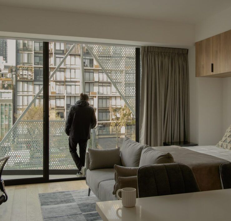 Interior de loft en Casa Roma 350 con ventanal y vista a la Ciudad de México