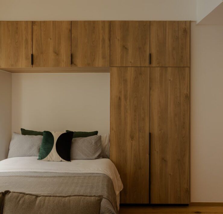 Recámara de un loft de Casa Roma 350 con cabecera de madera y cocina integrada