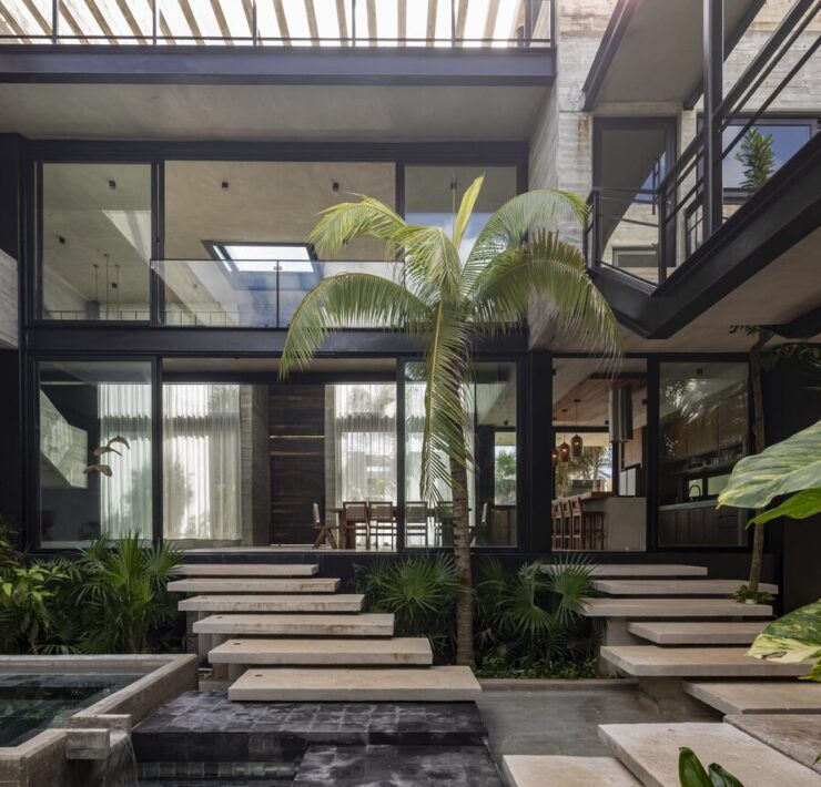 Patio central de Casa Vihara con escalinatas sobre espejo de agua y doble altura