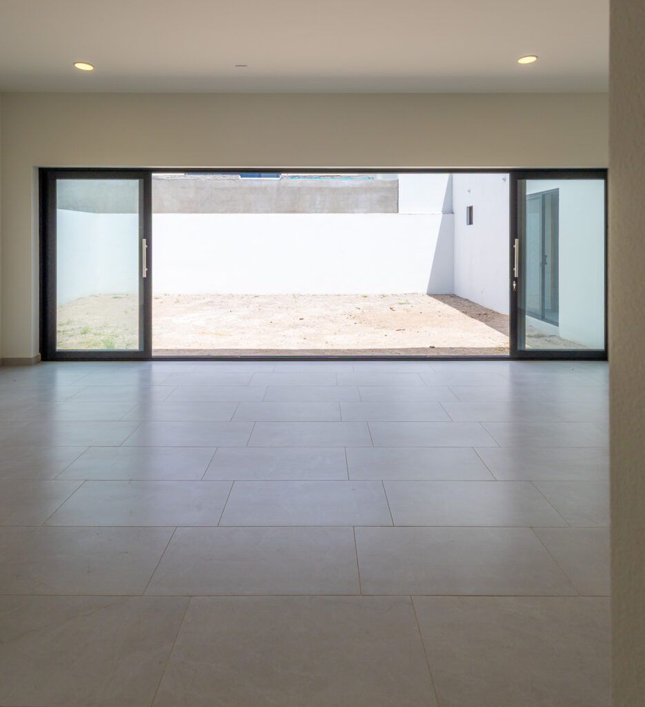 Sala comedor de Casa Arrullo con gran ventanal al patio en Concordia Residencial