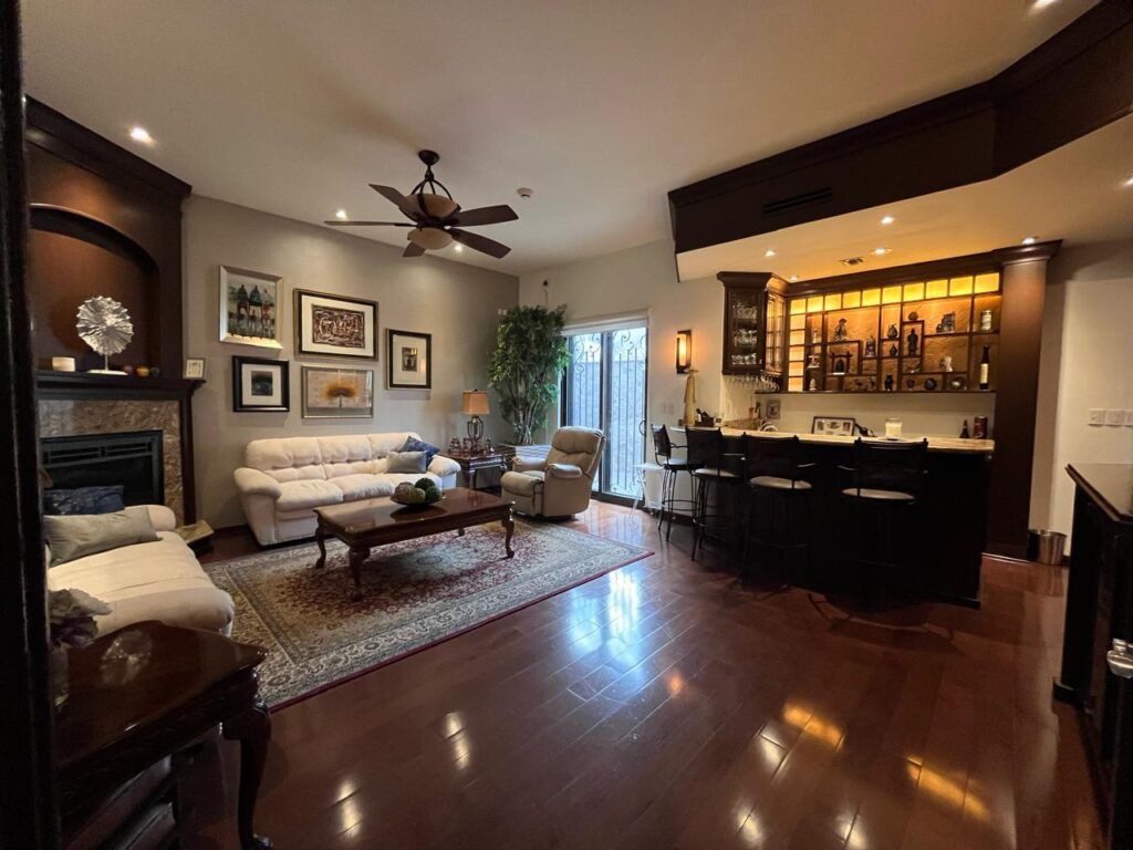 Sala con bar y chimenea en muebles y pisos en madera en La Jolla Residencial