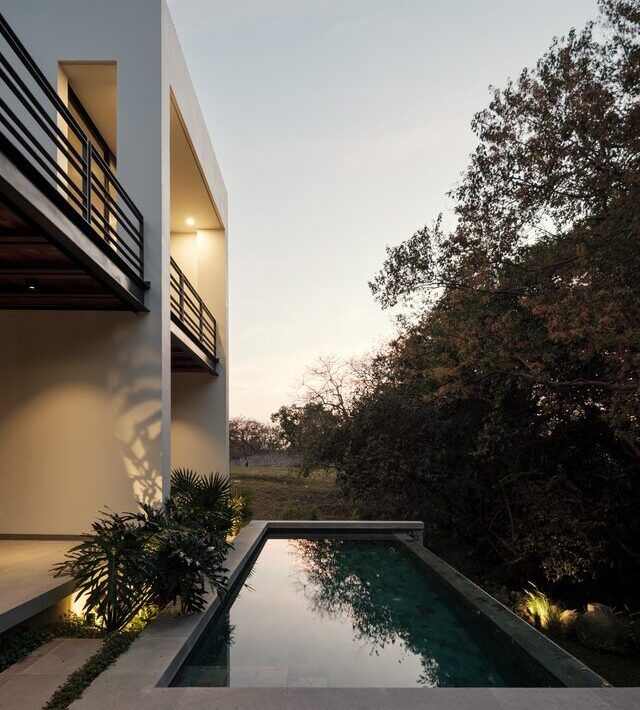 Alberca de Casa Amadar orientada al jardín al atardecer