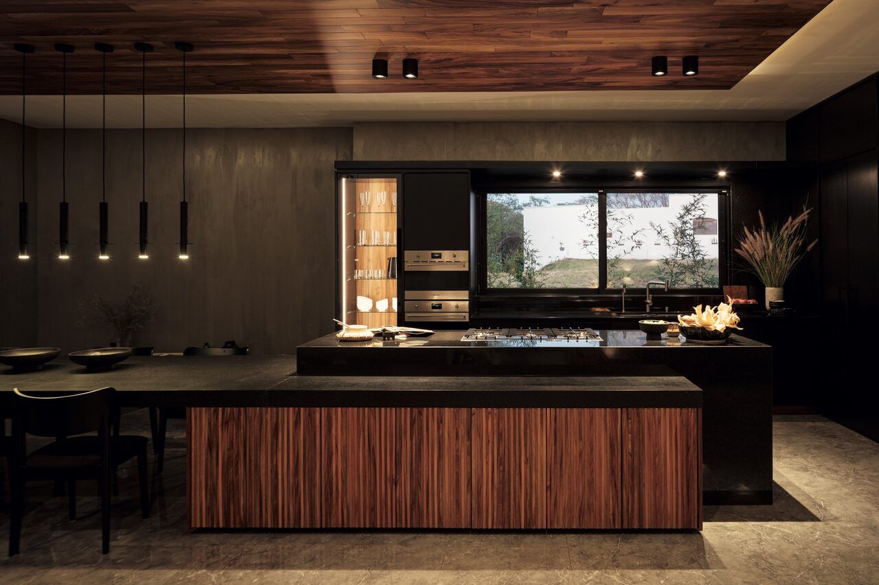 Cocina y comedor integrados de Casa Amadar con isla de madera