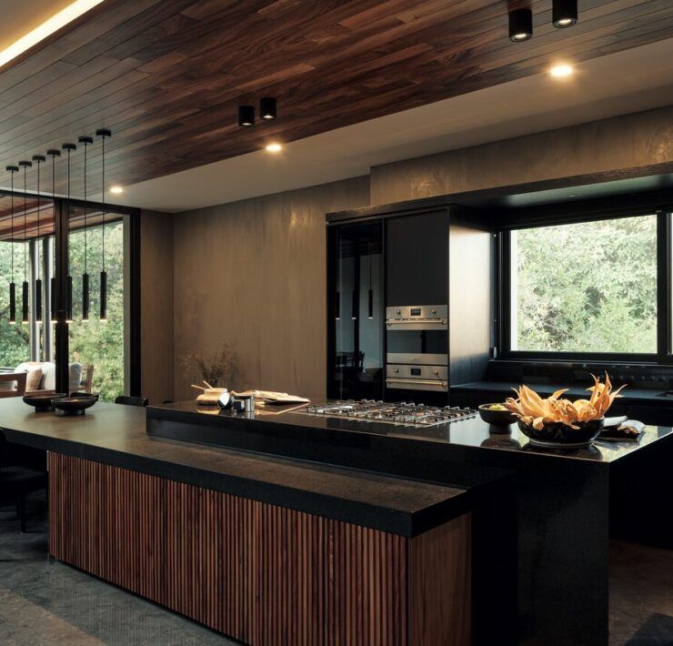 Cocina de Casa Amadar con isla de madera y ventanal al jardín