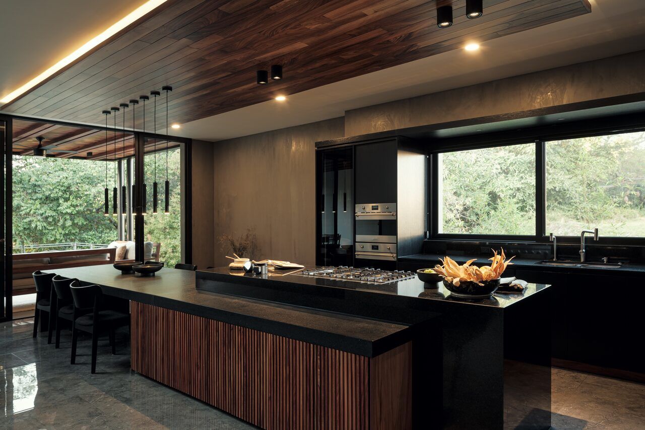 Cocina de Casa Amadar con isla de madera y ventanal al jardín