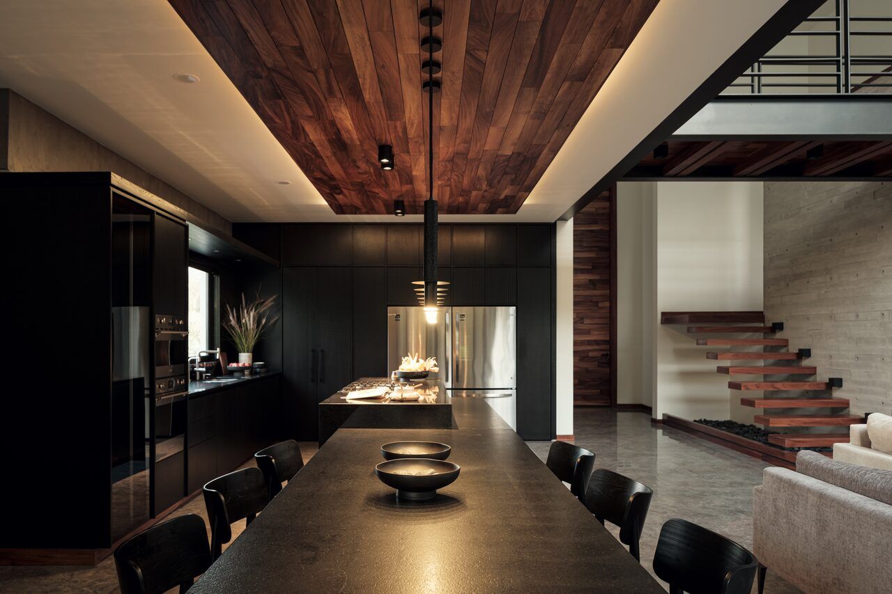 Comedor de Casa Amadar con mesa larga y techo de madera