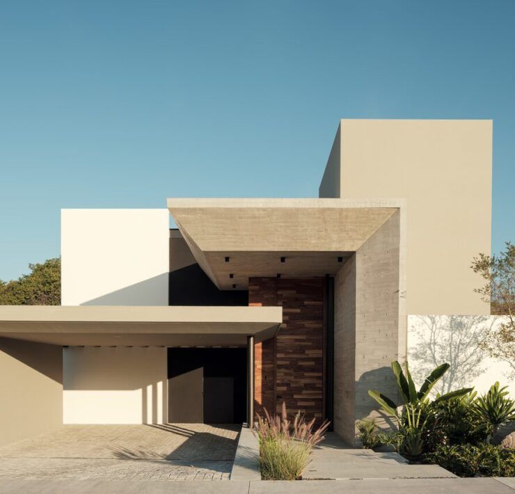 Fachada de Casa Amadar con volados de concreto y jardín"