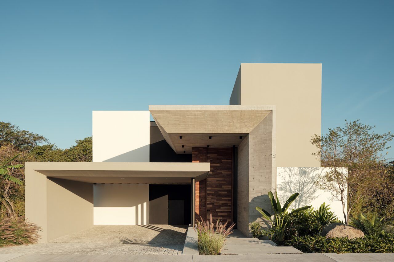 Fachada de Casa Amadar con volados de concreto y jardín"