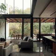 Sala de Casa Amadar abierta al jardín a través de grandes ventanales