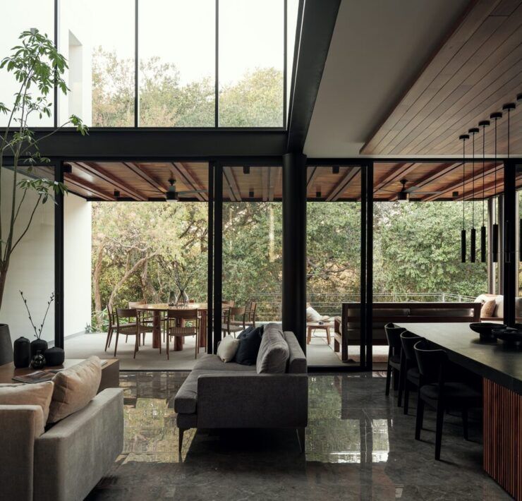 Sala de Casa Amadar abierta al jardín a través de grandes ventanales