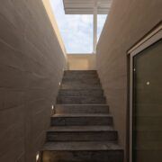 Escalera de Casa Martinica iluminada por un tragaluz hacia el cielo