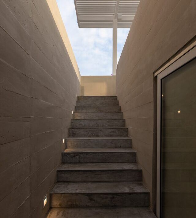 Escalera de Casa Martinica iluminada por un tragaluz hacia el cielo