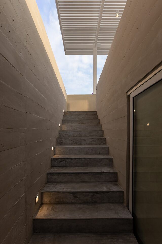 Escalera de Casa Martinica iluminada por un tragaluz hacia el cielo