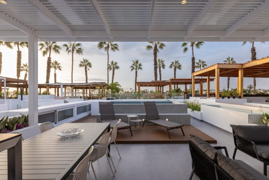 Comedor exterior en la terraza de Casa Martinica bajo pérgola con vista