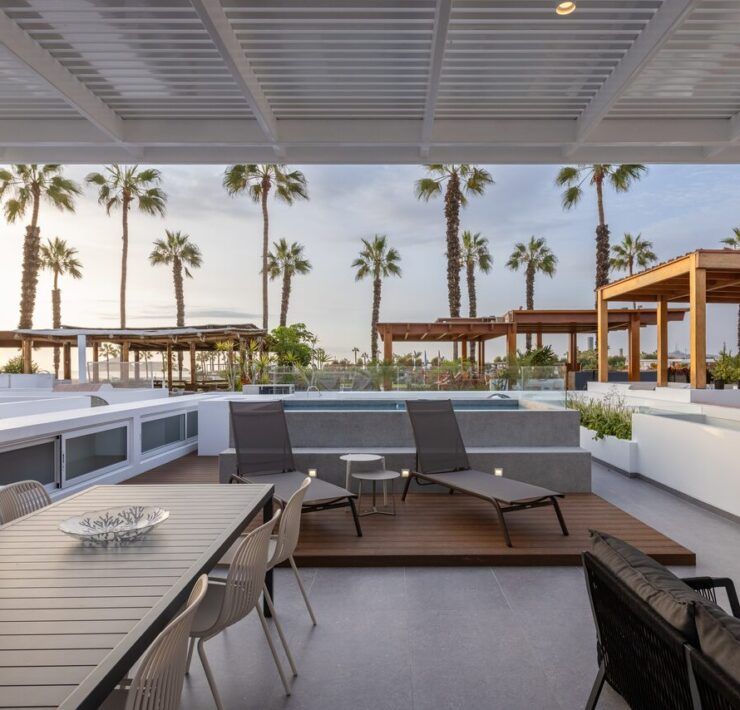 Comedor exterior en la terraza de Casa Martinica bajo pérgola con vista