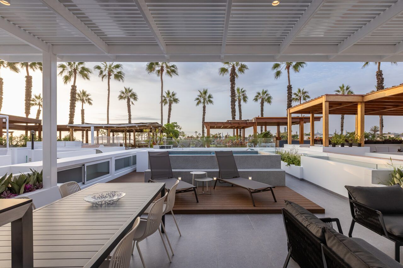 Comedor exterior en la terraza de Casa Martinica bajo pérgola con vista