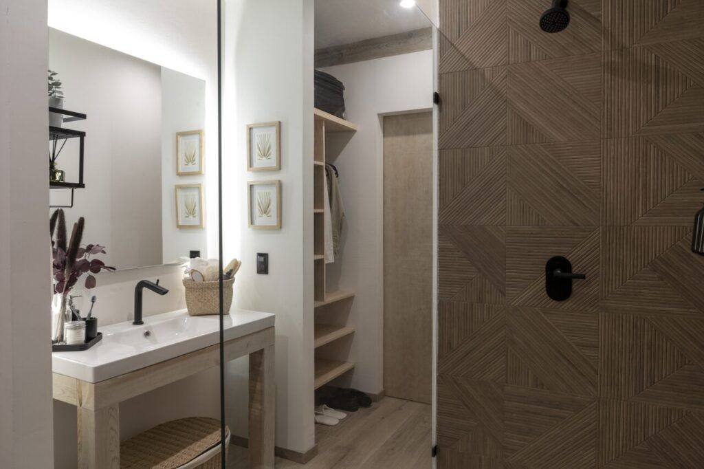 Baño de Casa Yoli con lavabo, espejo y acabados cálidos