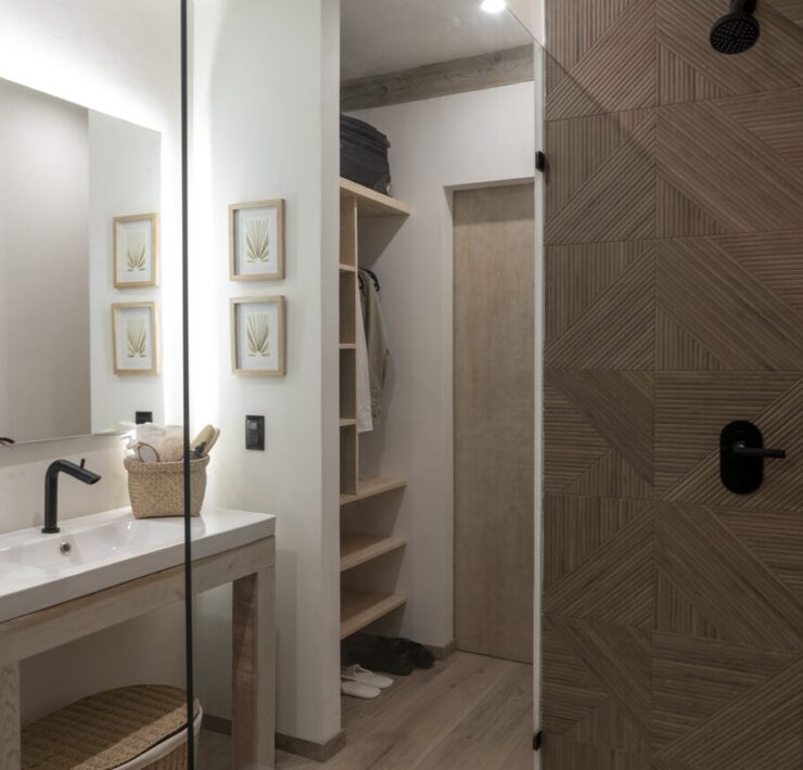 Baño de Casa Yoli con lavabo, espejo y acabados cálidos