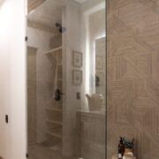Baño de Casa Yoli con regadera y acabados de madera