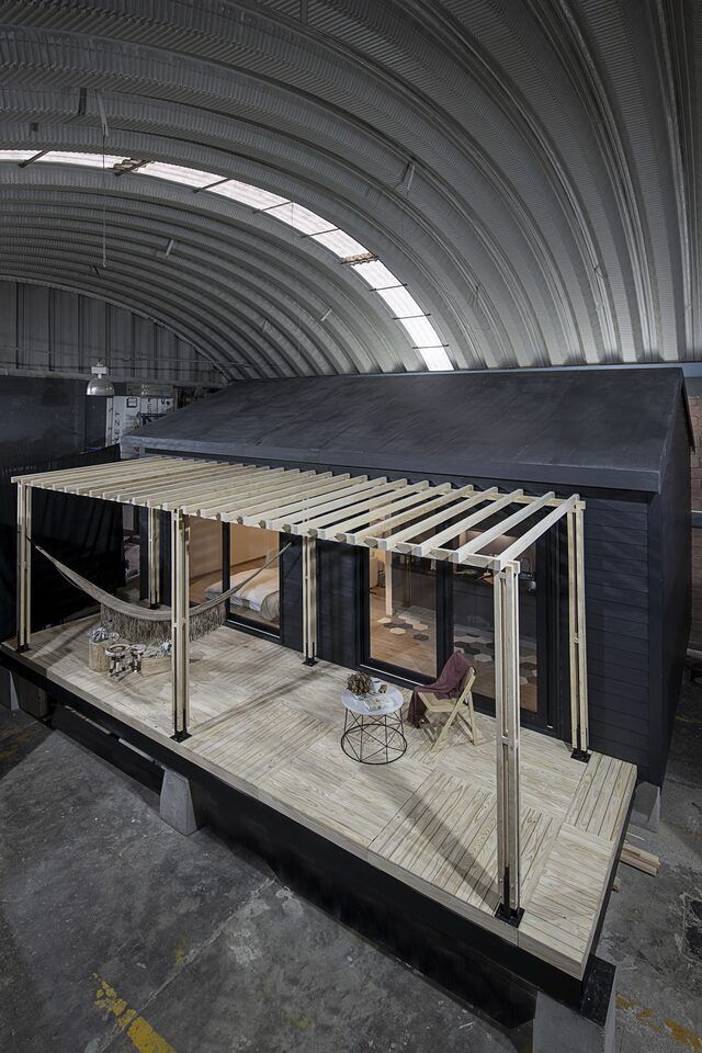 Casa Yoli de noche, tiny house sobre palafito con terraza iluminada