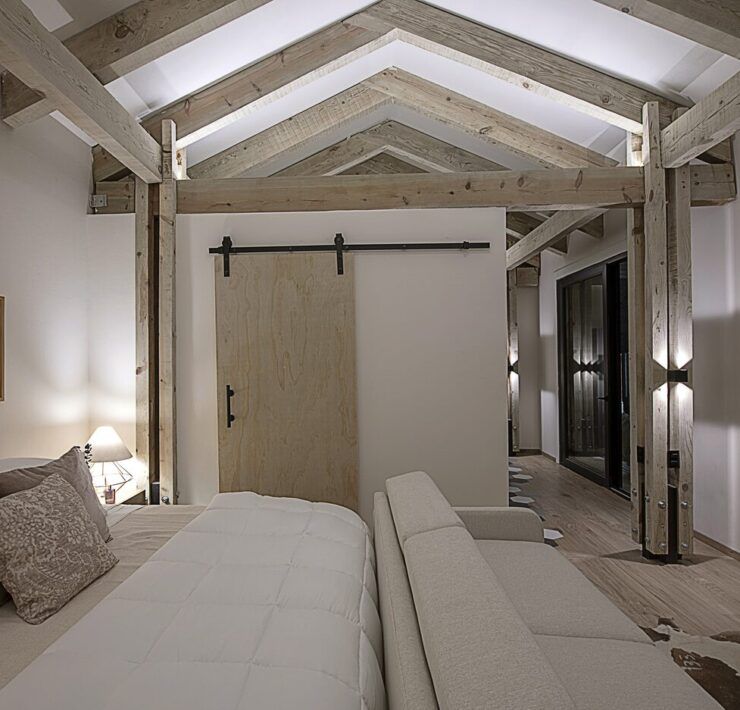Recámara de Casa Yoli con puerta tipo granero y techo de madera