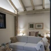 Interior de Casa Yoli con recámara y sala integradas bajo techo de madera