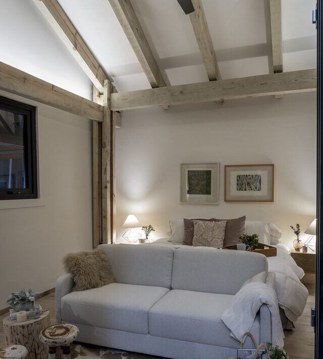 Interior de Casa Yoli con recámara y sala integradas bajo techo de madera