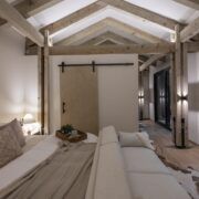 Recámara de Casa Yoli con techo de madera a dos aguas y puerta tipo granero