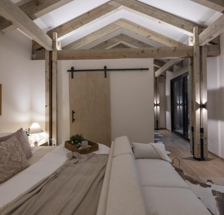 Recámara de Casa Yoli con techo de madera a dos aguas y puerta tipo granero