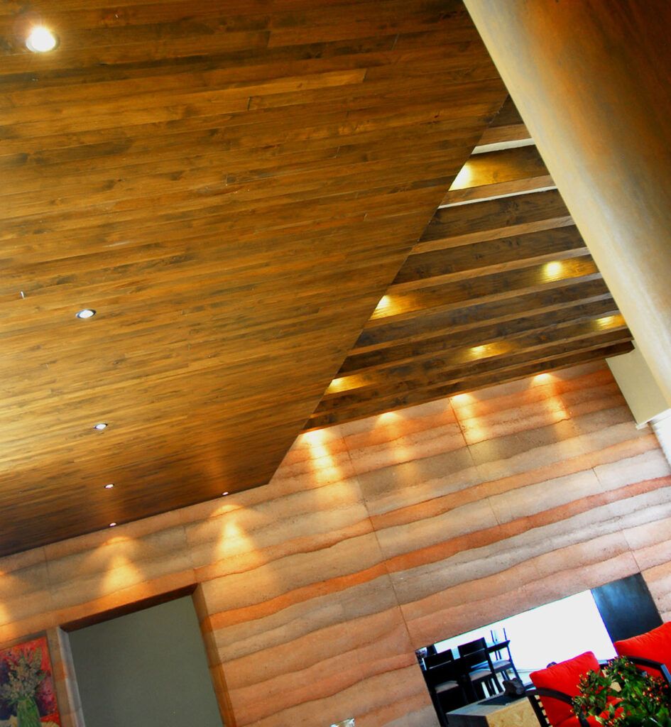 Detalles en techo de madera y muro en rammed earth en Casa Adobe