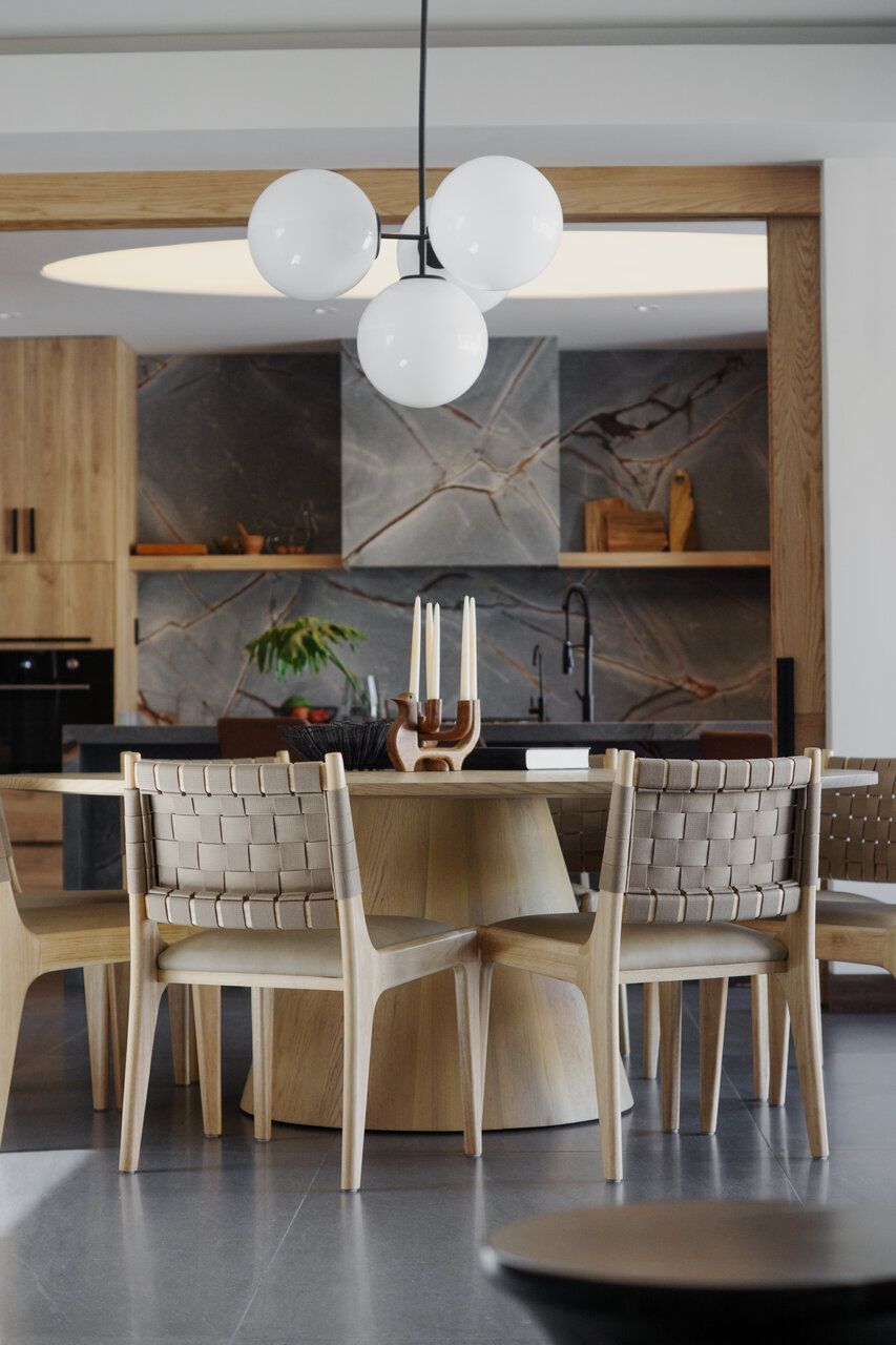 Comedor de Casa Ficus con mesa redonda de madera y lámpara de esferas